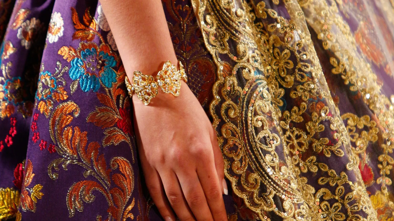 Brazalete dorado de fallera sobre el traje
